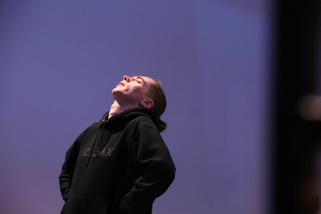 A man stares up into the sky, distressed.