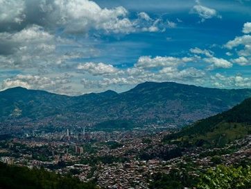 Image of Medellín valley, city in the centre, mountains on either side and in background.