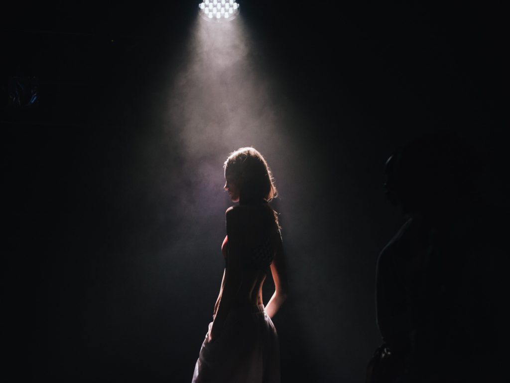 A performer standing in a spolight
