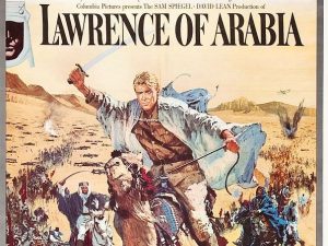 A psoter for the film Lawrence of Arabia. Lawrence is pictured riding a camel, arm aloft