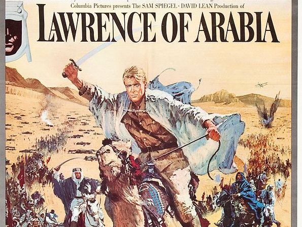 A psoter for the film Lawrence of Arabia. Lawrence is pictured riding a camel, arm aloft