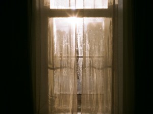 Sunlight shining through a door with curtains